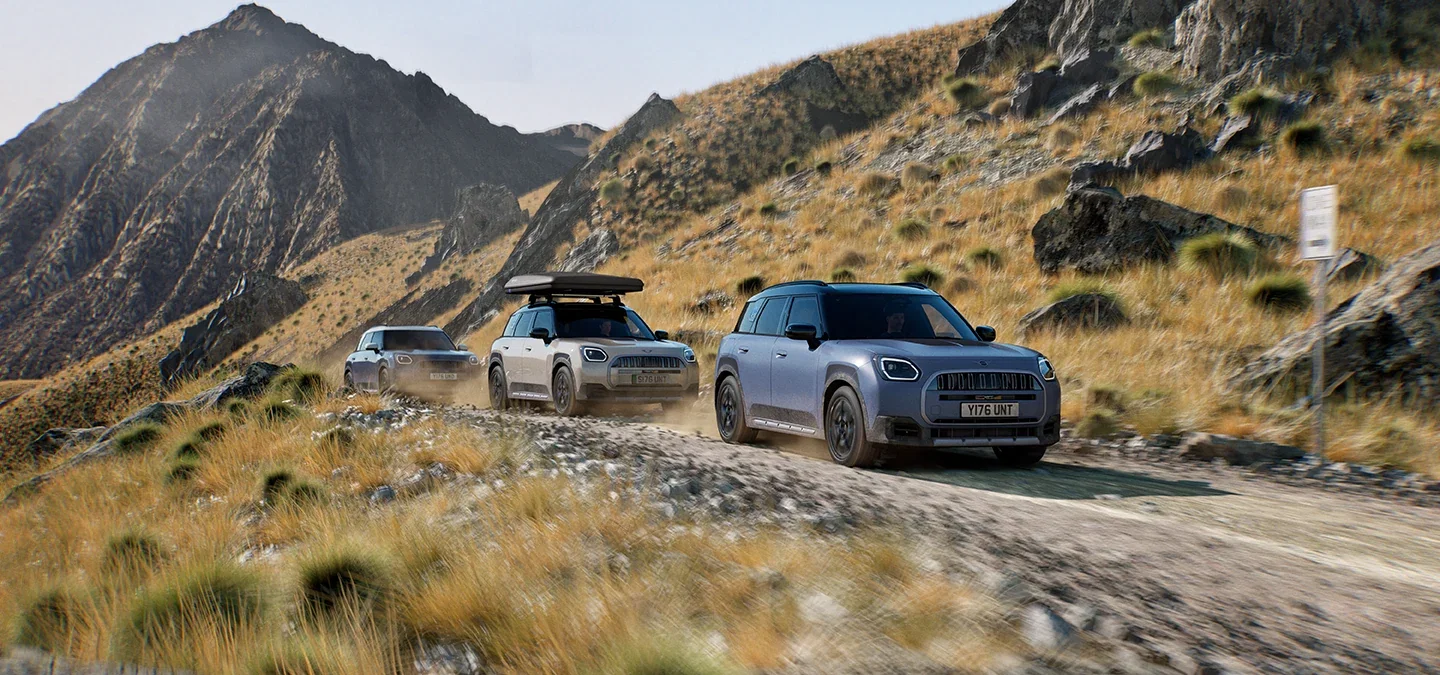 MINI Countryman vehicles driving along a mountain road.