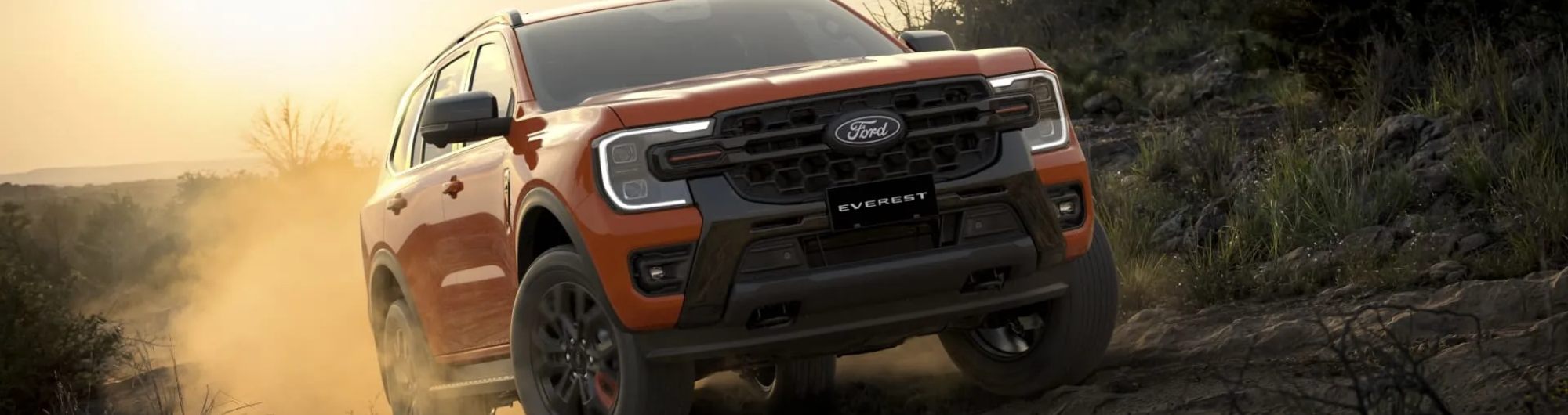 Orange 2026 Ford Everest navigating a dusty rocky trail