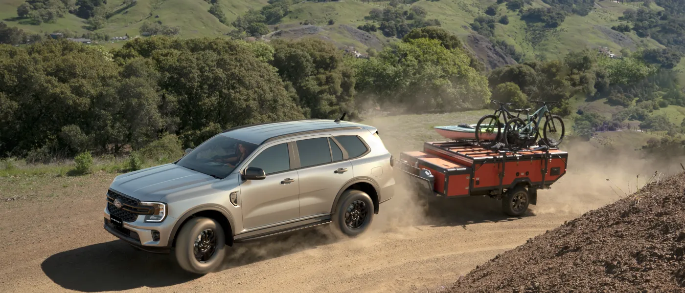 Ford Everest towing a trailer with bikes on a dusty trail