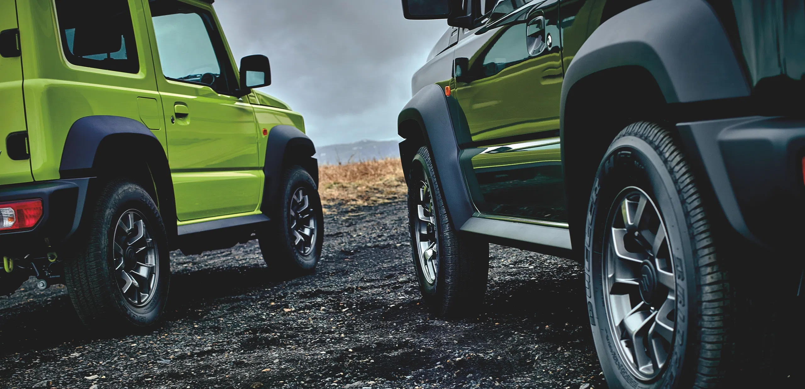 Black Suzuki Jimny driving on a scenic road