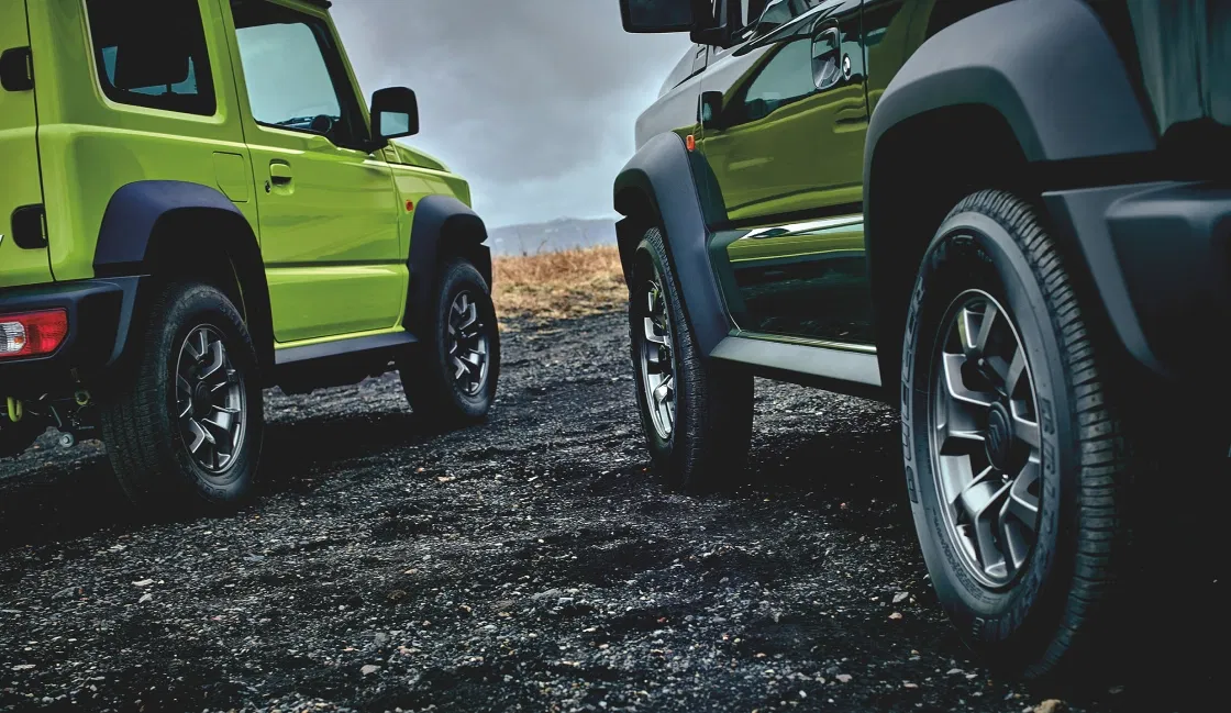 Two Jimnys with rugged styling on rocky terrain