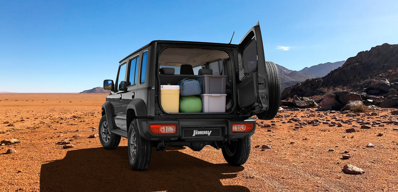 Man camping near a green Suzuki Jimny parked on rocky terrain