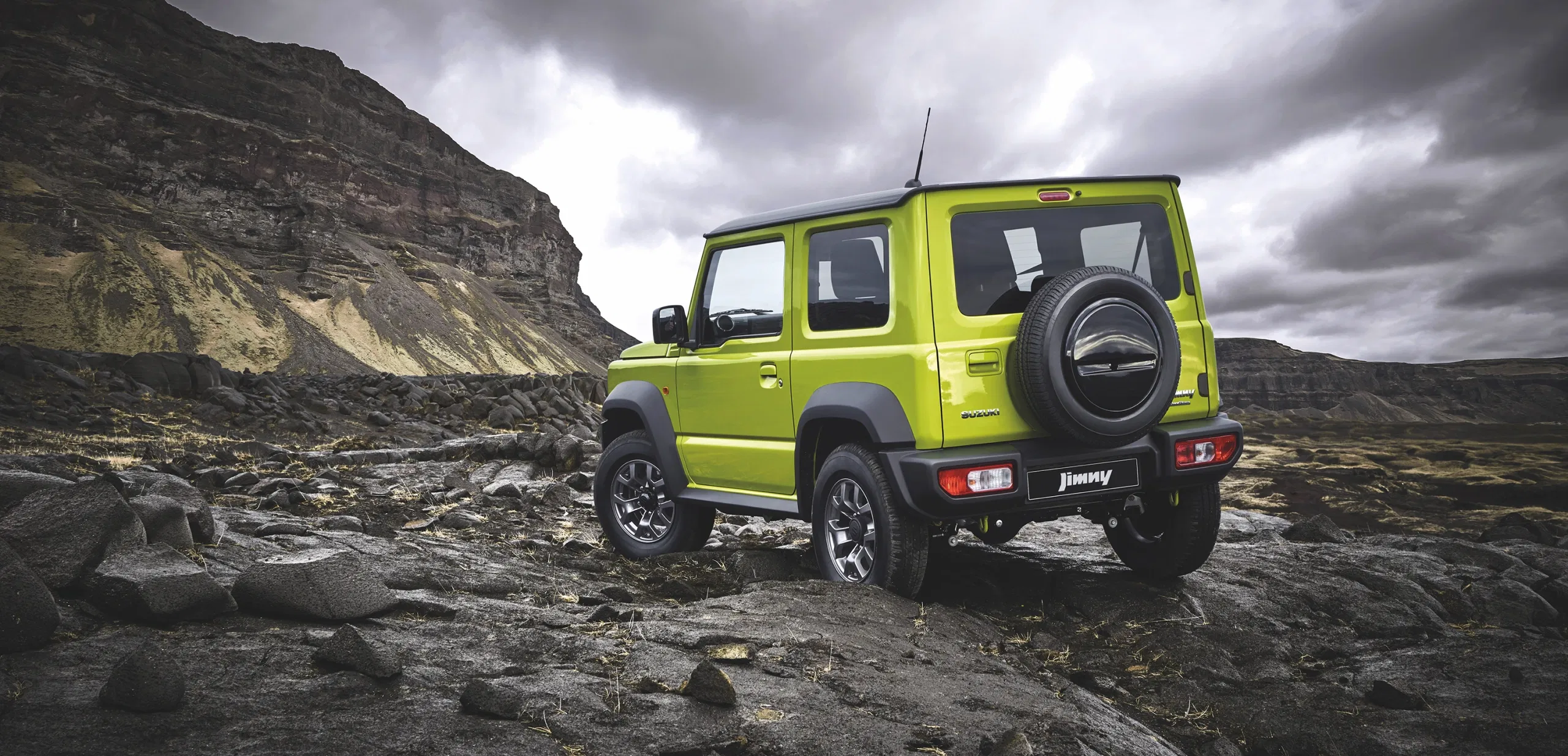 Suzuki Jimny at the edge of a cliff with scenic views