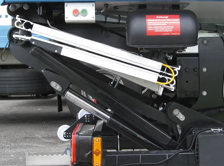 A Palfinger foldable tail lift stowed beneath the rear of a truck.